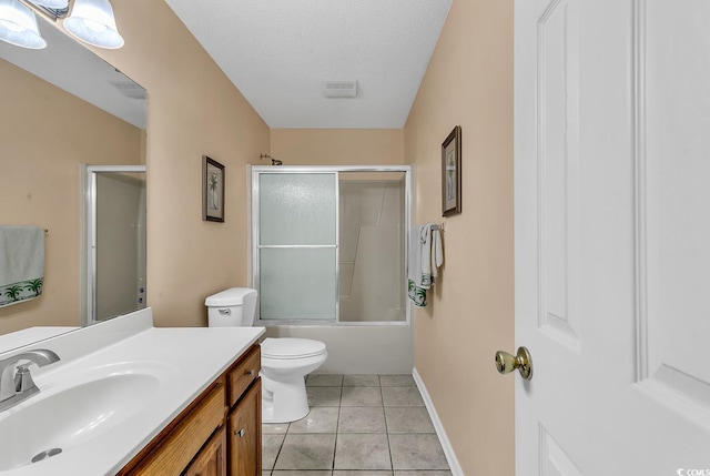 bathroom with a textured ceiling, tile patterned flooring, toilet, shower / bath combination with glass door, and vanity