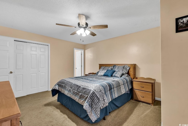 bedroom with light carpet, baseboards, ceiling fan, a textured ceiling, and a closet