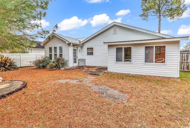 rear view of property with fence and metal roof