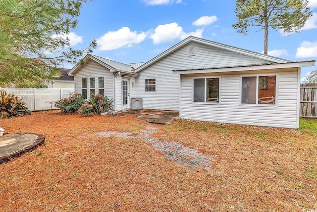rear view of house featuring metal roof and fence private yard