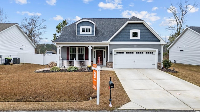 view of front of property with covered porch, concrete driveway, central AC unit, fence, and a garage