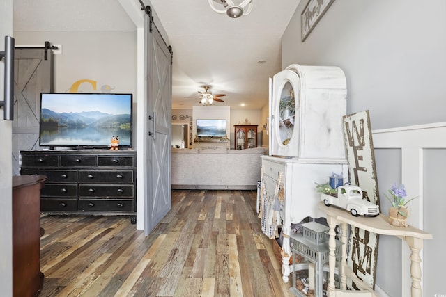 hallway with a barn door and wood-type flooring