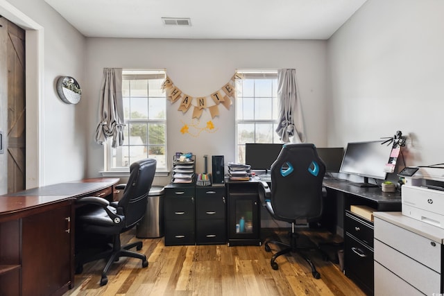 office featuring visible vents, a wealth of natural light, and light wood-style flooring