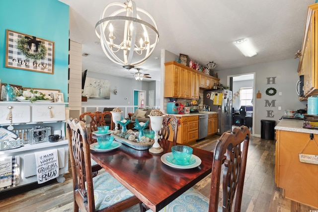 dining area featuring light wood-type flooring and ceiling fan with notable chandelier