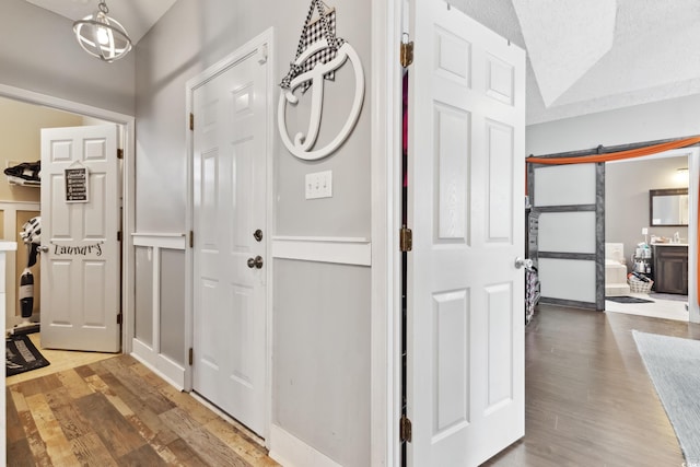 entryway with wood finished floors, a textured ceiling, and a barn door