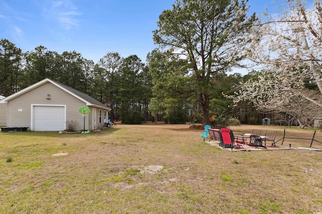 view of yard with a garage and an outbuilding