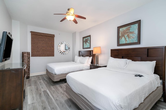 bedroom featuring baseboards, a ceiling fan, and light wood-style floors