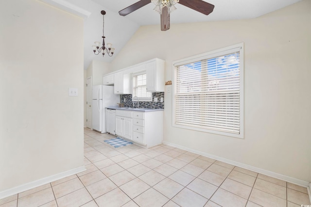 kitchen with dark countertops, white appliances, white cabinetry, and a sink