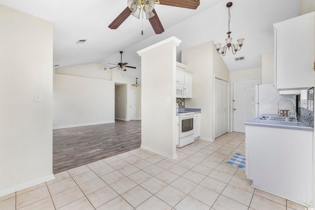 kitchen with light tile patterned floors, visible vents, white cabinets, white appliances, and ceiling fan with notable chandelier