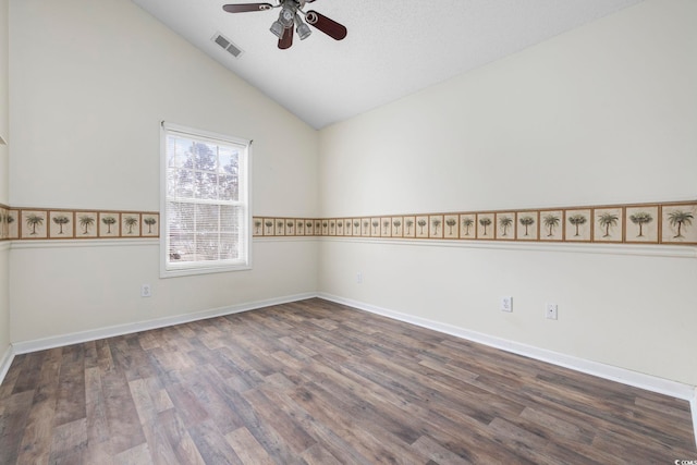 spare room featuring lofted ceiling, visible vents, baseboards, a ceiling fan, and dark wood-style floors