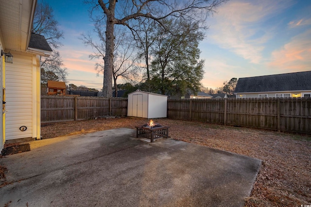 view of yard featuring an outdoor fire pit, a patio area, a fenced backyard, and a storage shed