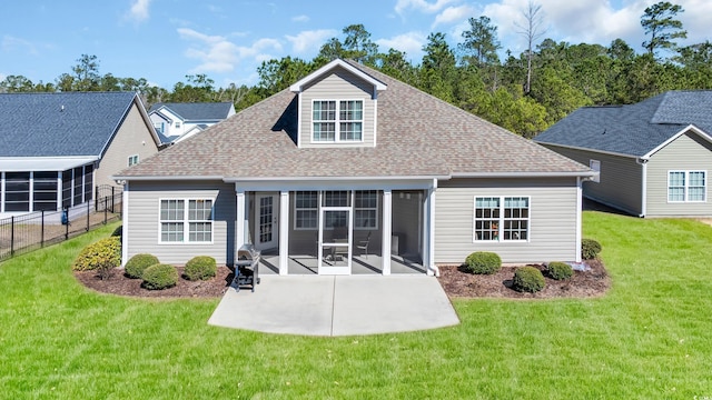 rear view of property with a lawn, a patio area, and a sunroom