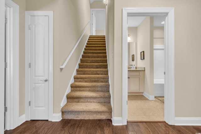 stairway featuring baseboards and wood finished floors