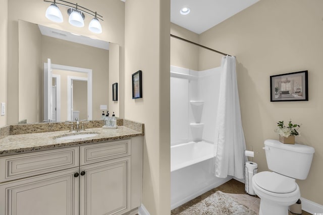 bathroom featuring toilet, shower / bath combo with shower curtain, vanity, baseboards, and tile patterned floors