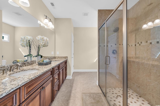 full bath with a sink, a shower stall, baseboards, and double vanity