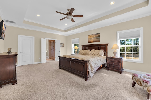 bedroom with a raised ceiling, multiple windows, visible vents, and baseboards