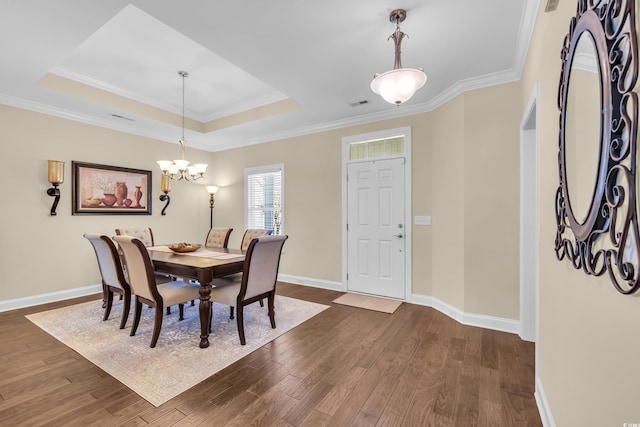 dining space featuring crown molding, dark wood-type flooring, a raised ceiling, and baseboards