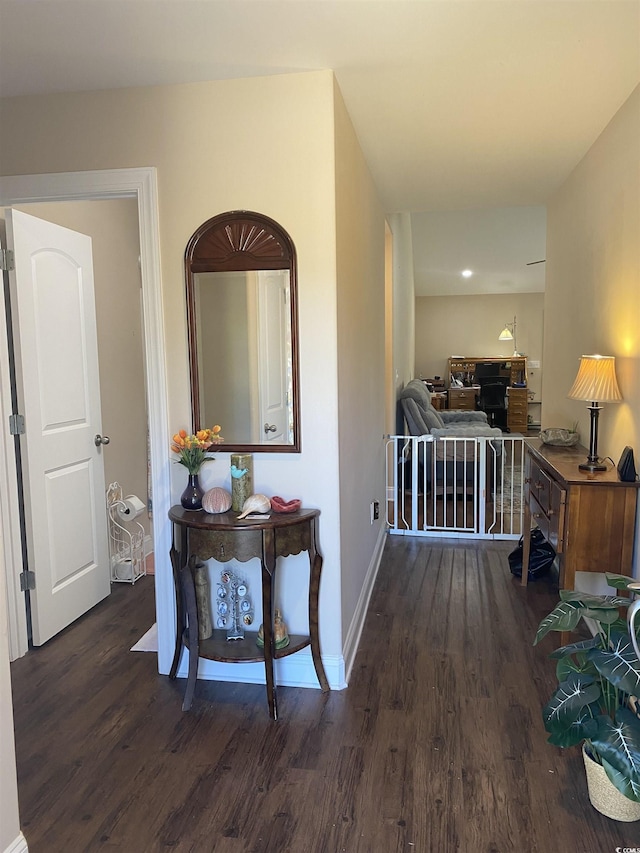 corridor with dark wood-style flooring and baseboards