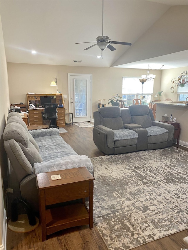 living area with vaulted ceiling, visible vents, and dark wood finished floors