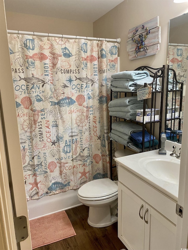 bathroom featuring toilet, wood finished floors, shower / bath combo with shower curtain, and vanity