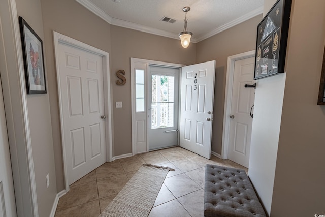 foyer entrance featuring light tile patterned floors, baseboards, visible vents, and ornamental molding