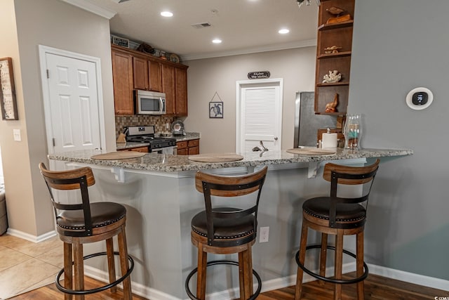 kitchen featuring tasteful backsplash, brown cabinetry, appliances with stainless steel finishes, ornamental molding, and open shelves