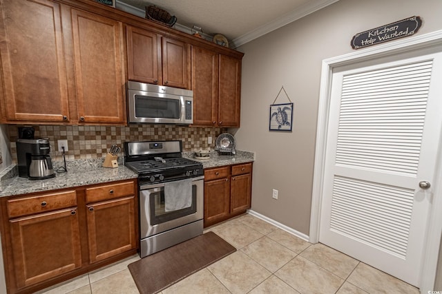 kitchen with decorative backsplash, appliances with stainless steel finishes, brown cabinetry, ornamental molding, and light tile patterned flooring