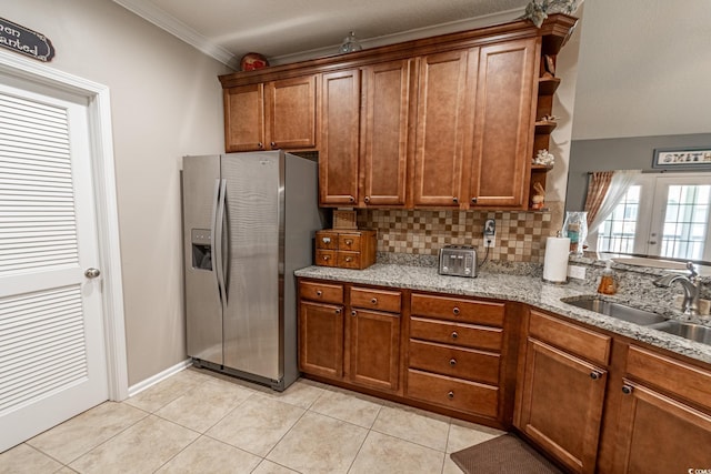 kitchen with brown cabinets, a sink, stainless steel refrigerator with ice dispenser, and open shelves