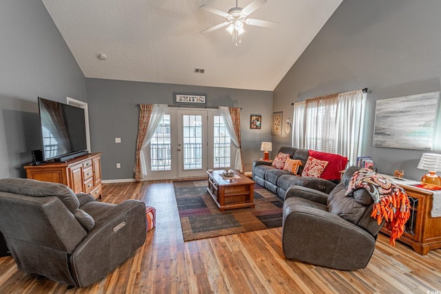 living room with visible vents, ceiling fan, wood finished floors, french doors, and high vaulted ceiling