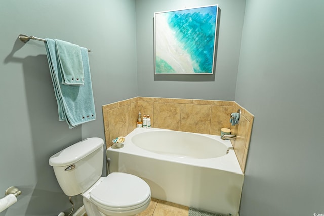 bathroom with tile patterned flooring, a garden tub, and toilet