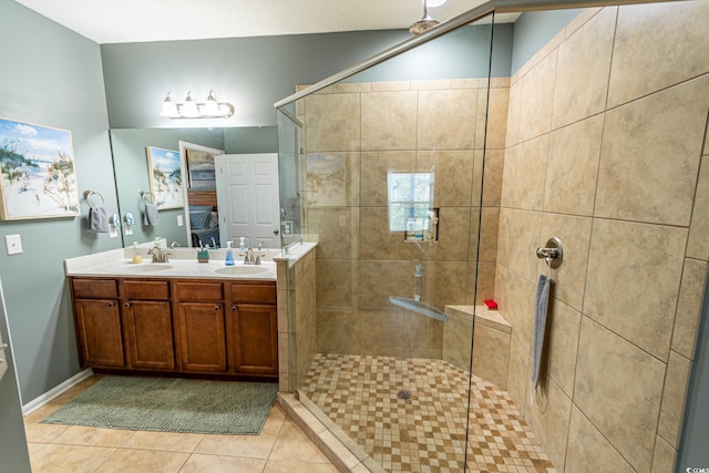 full bath with a sink, double vanity, a shower stall, and tile patterned floors