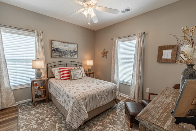 bedroom with visible vents, baseboards, and wood finished floors