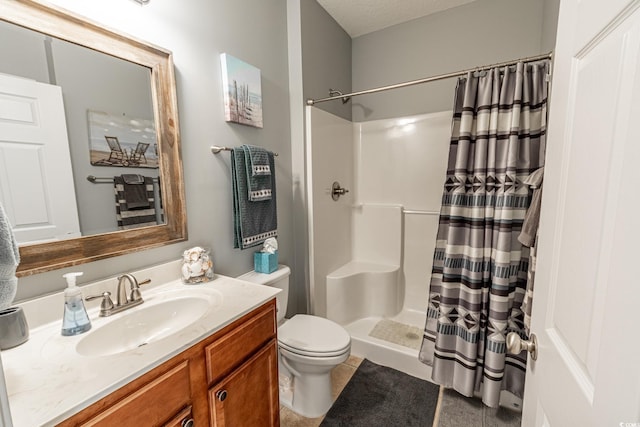 bathroom featuring a stall shower, vanity, and toilet