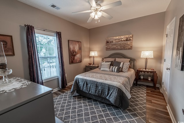 bedroom featuring baseboards, visible vents, and dark wood finished floors