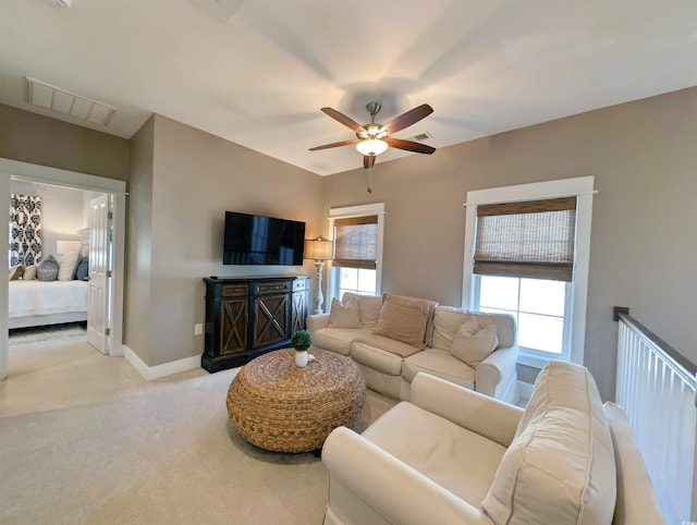 living room with visible vents, ceiling fan, light carpet, and baseboards