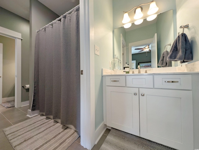 ensuite bathroom featuring a ceiling fan, connected bathroom, vanity, tile patterned flooring, and baseboards