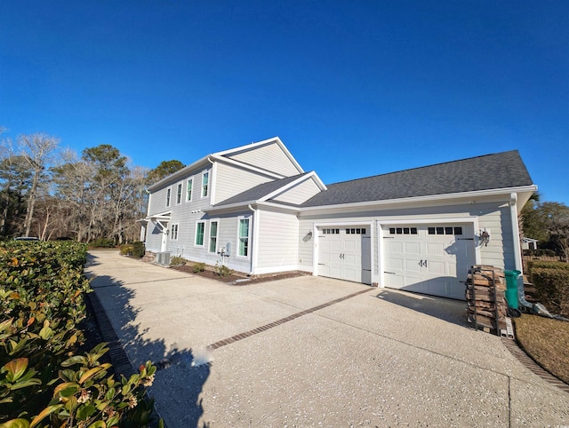 view of front of home featuring a garage, driveway, and a shingled roof