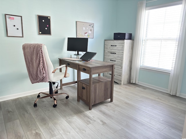 home office with light wood finished floors and baseboards