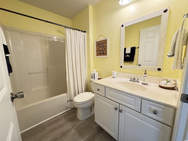 full bath with toilet, shower / bath combo with shower curtain, wood finished floors, and vanity