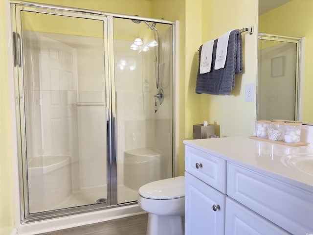 full bathroom with a stall shower, vanity, and toilet