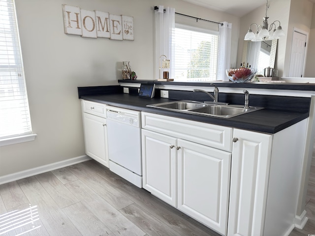 kitchen with dishwasher, dark countertops, a sink, and white cabinets