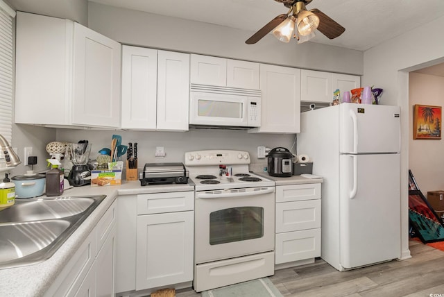 kitchen with light countertops, white cabinets, a sink, light wood-type flooring, and white appliances