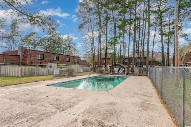 pool with a patio area and fence