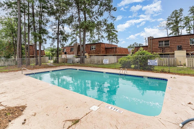 pool with a patio and fence