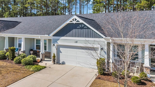 view of front facade with covered porch, driveway, roof with shingles, and a garage