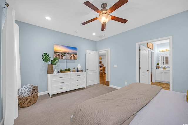 carpeted bedroom with ensuite bathroom, recessed lighting, and baseboards