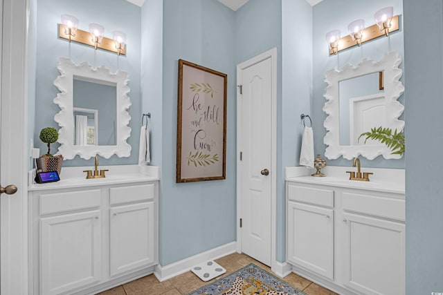 bathroom featuring tile patterned flooring, two vanities, and a sink