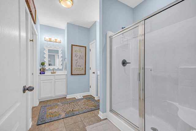 bathroom with baseboards, a stall shower, vanity, and tile patterned floors