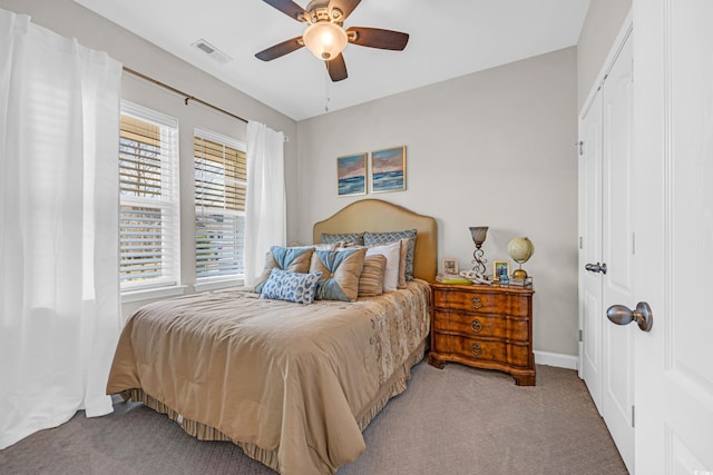 carpeted bedroom with a ceiling fan, visible vents, and baseboards