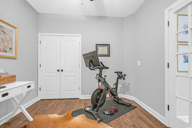 exercise area featuring wood finished floors and baseboards